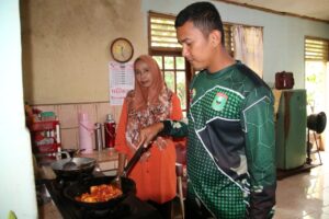 Anggota Satgas TMMD Bantu Salah Warga Memasak