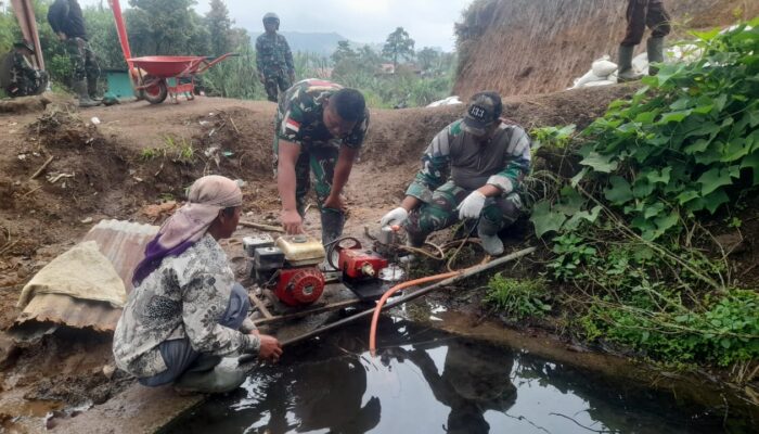 Satgas TMMD Bersama Warga Melakukan Penyiraman Air Pada Cor Beton